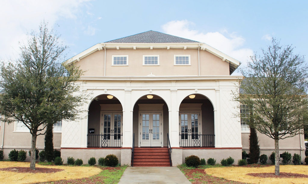 Mill Hill Community Arts Center, an auditorium with three arches in front of sets of double doors.