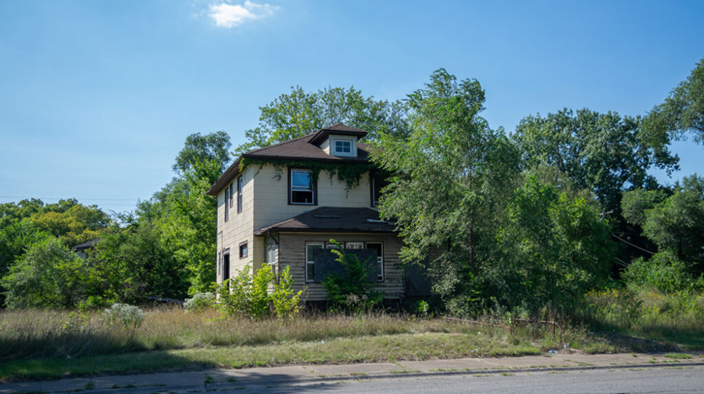 An abandoned home overgrown with weeds