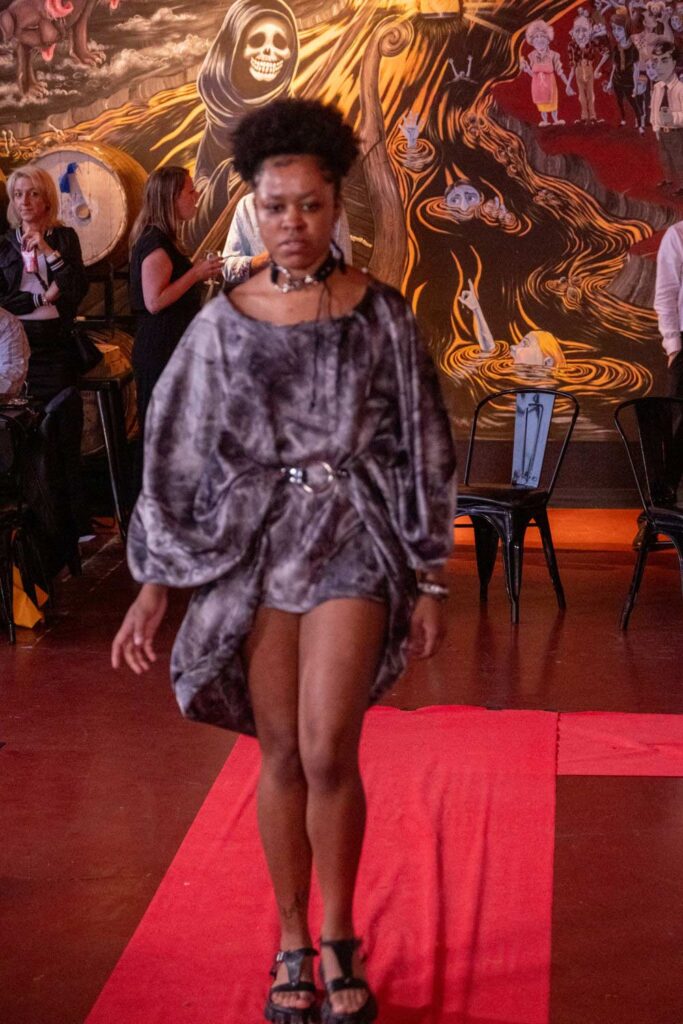 A young black woman models on the runway