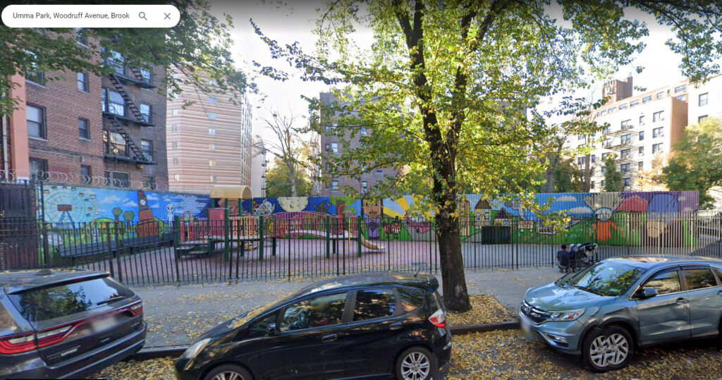 An image from Google Street View of Umma Park, on Woodruff Avenue, Brooklyn, New York. A fenced playground can be seen, surrounded by colorful murals.