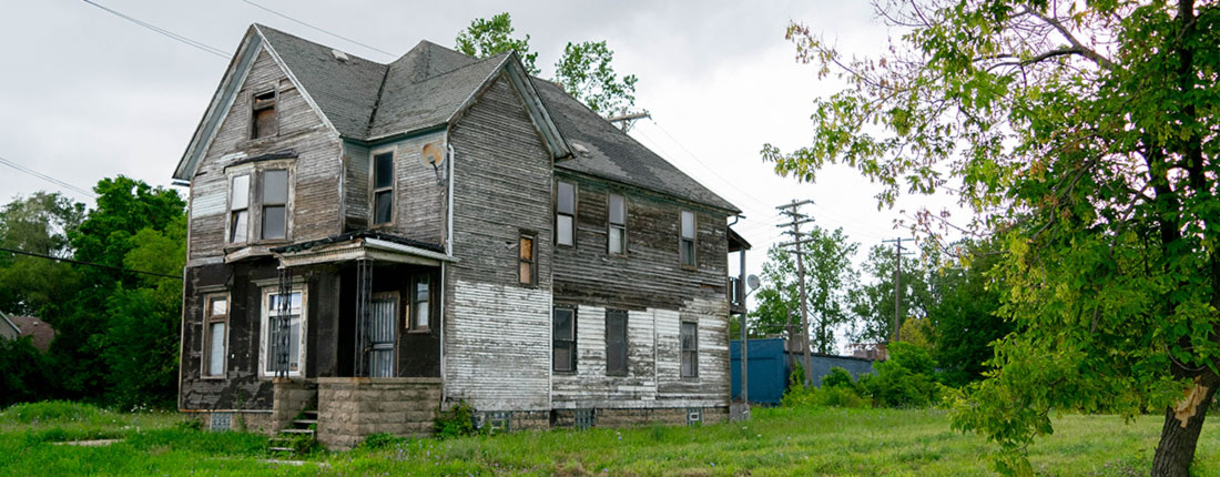 Single family home with boarded up windows.