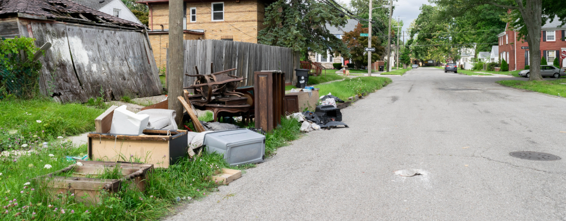 illegal-dumping-prevention-mi a pile of broken furniture and household trash on the side of the road