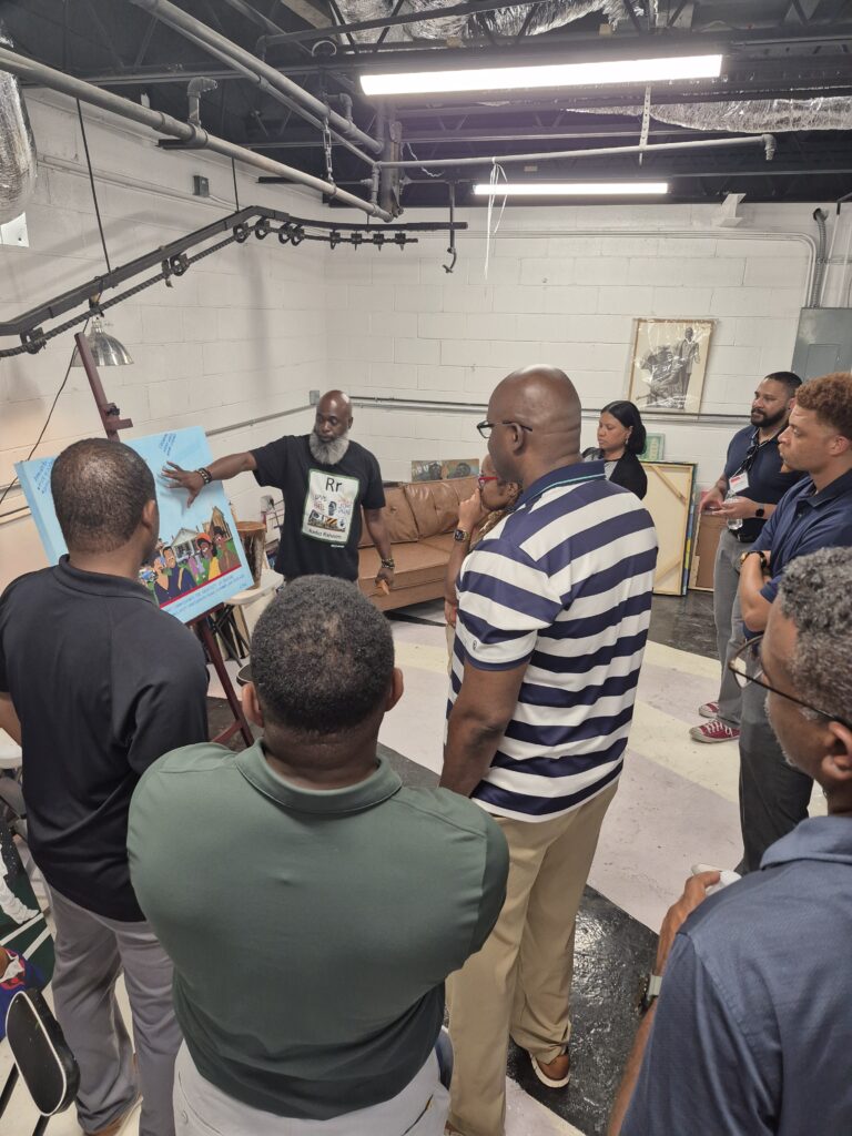 Kevin King gives Sparkling Commercial Corridors participants a tour of the King's Canvas studio space. (Photo: Community Progress)