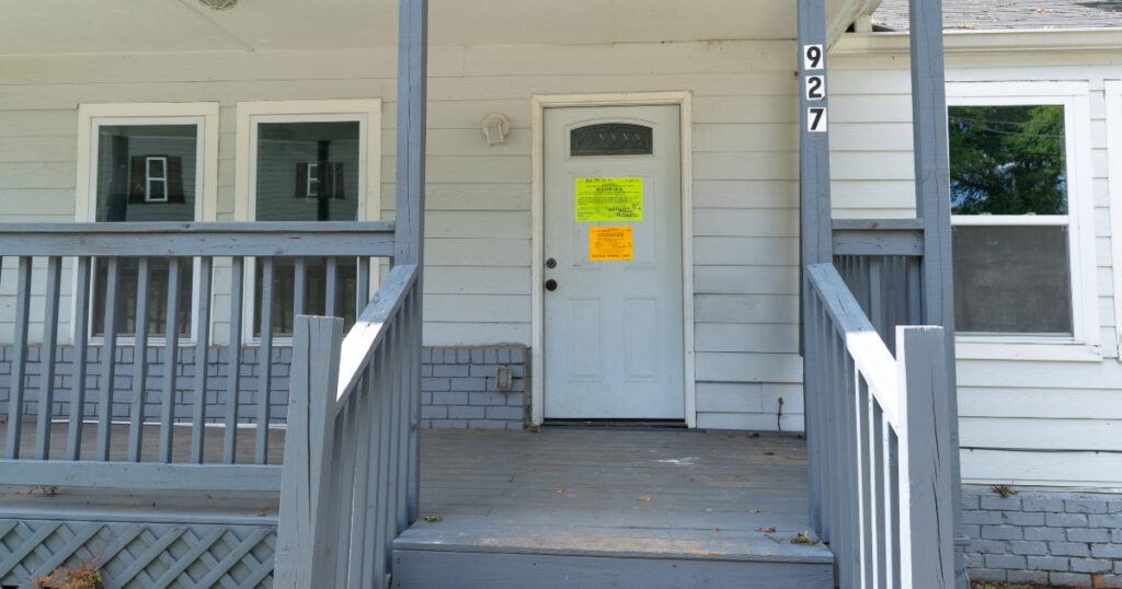 A home in Atlanta with a code enforcement violation posted. (Photo: Community Progress)