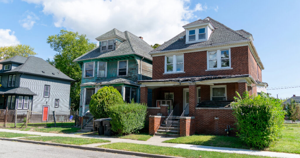 Two homes in Detroit show signs of deterioration, roof, and siding damage. (Photo: Community Progress)