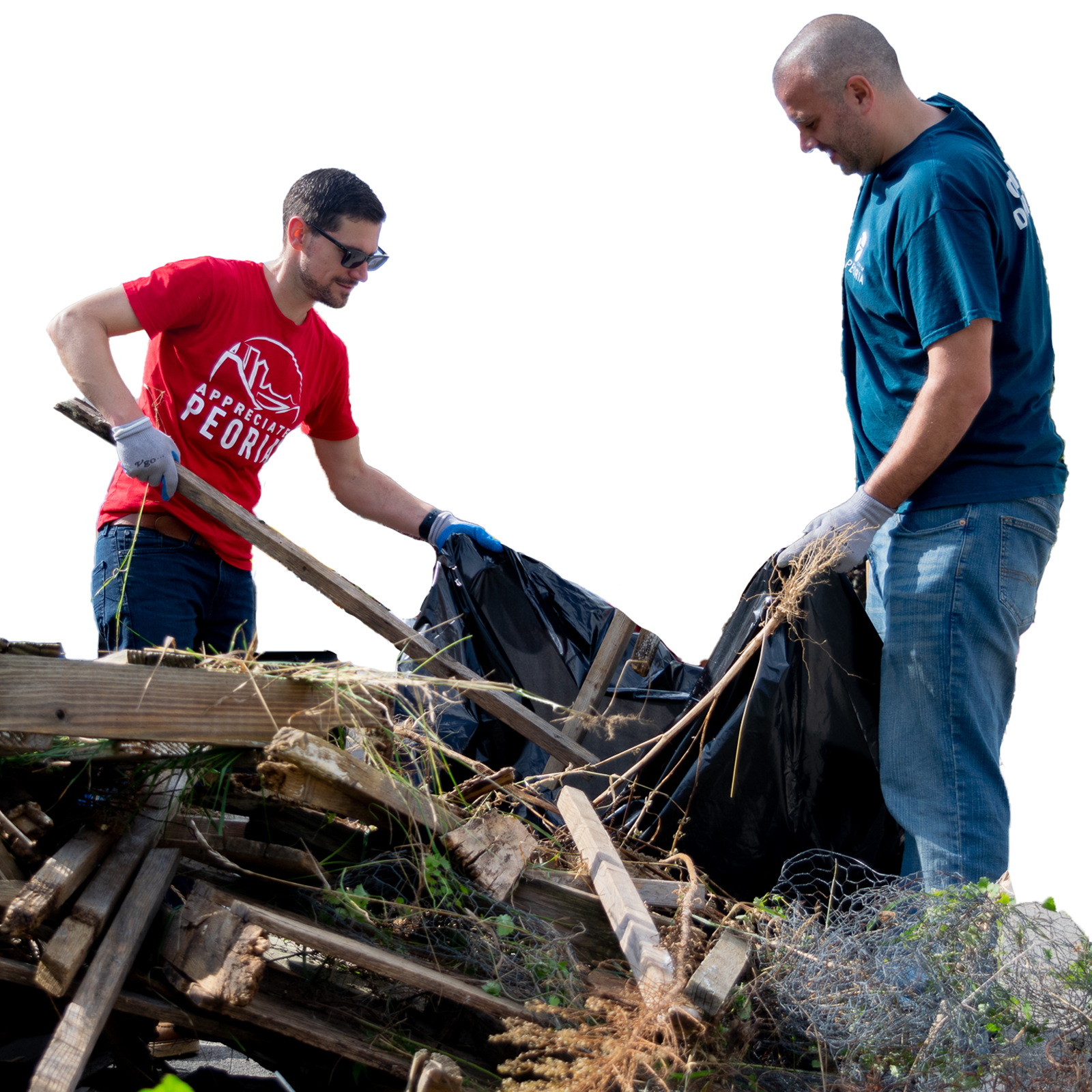 Two volunteers wearing gloves clear debris and wood scraps during a community cleanup.