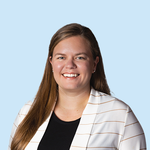 Headshot of Janell O'Keefe on a blue background