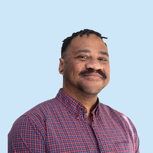 Headshot of Justin Godard on a blue background
